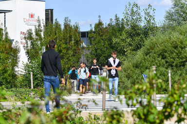 Étudiants marchant sur l'allée du Pôle Universitaire Niortais, bâtiment de l'Université de Poitiers visible en arrière-plan