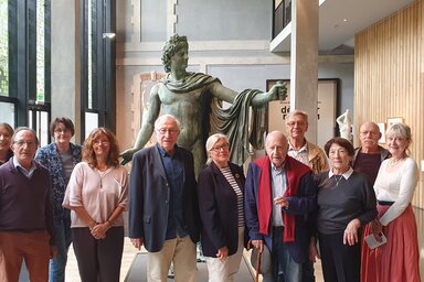Le nouveau conseil d'administration des Amis des musées de Niort, avec sa présidente Catherine Piot, posant devant une statue en bronze au musée.