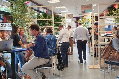 Tables de rendez-vous entre fournisseurs locaux et acheteurs publics et privés, bannière Niort Agglo visible en arrière-plan.