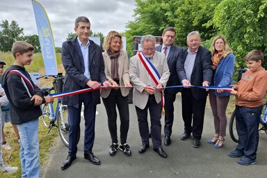 Jérôme Baloge, président de Niort Agglo, coupe le ruban tricolore avec des élus locaux, entouré d'enfants sur la piste